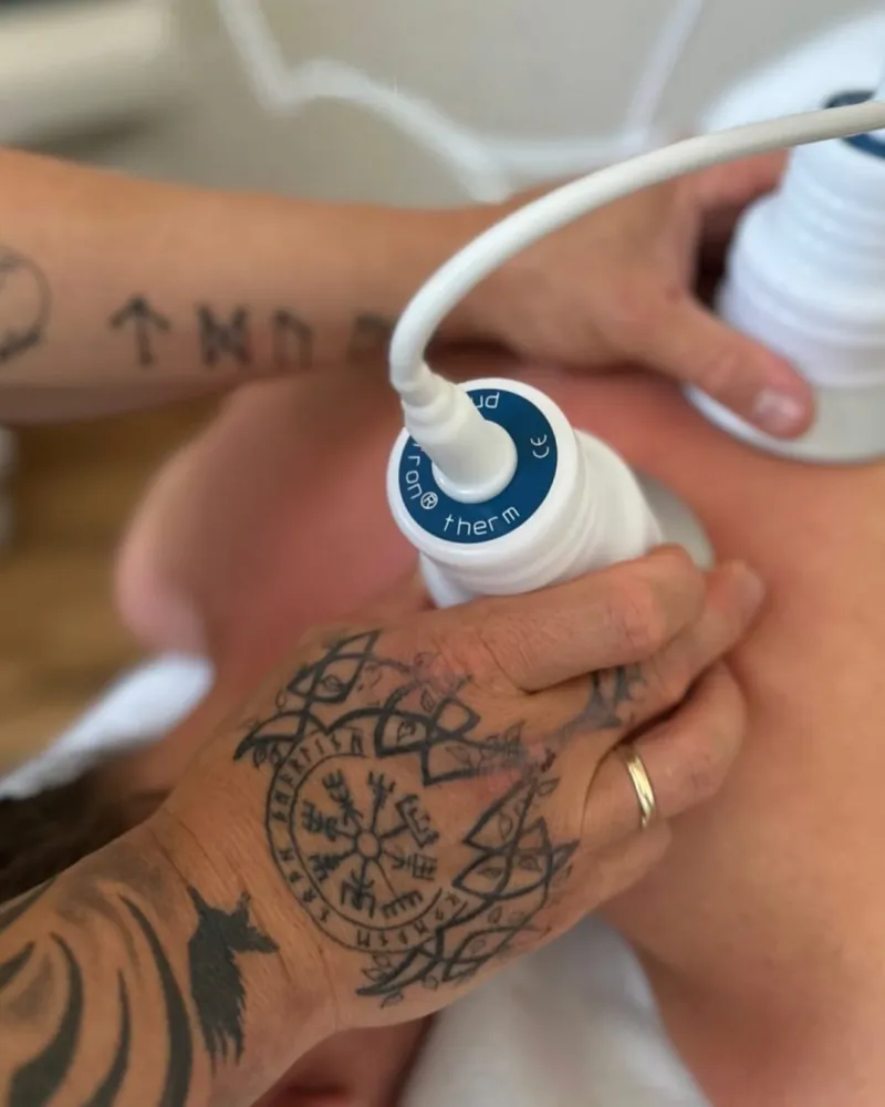 Gerätgestützte Behandlung an Schulter und Nacken einer Patientin