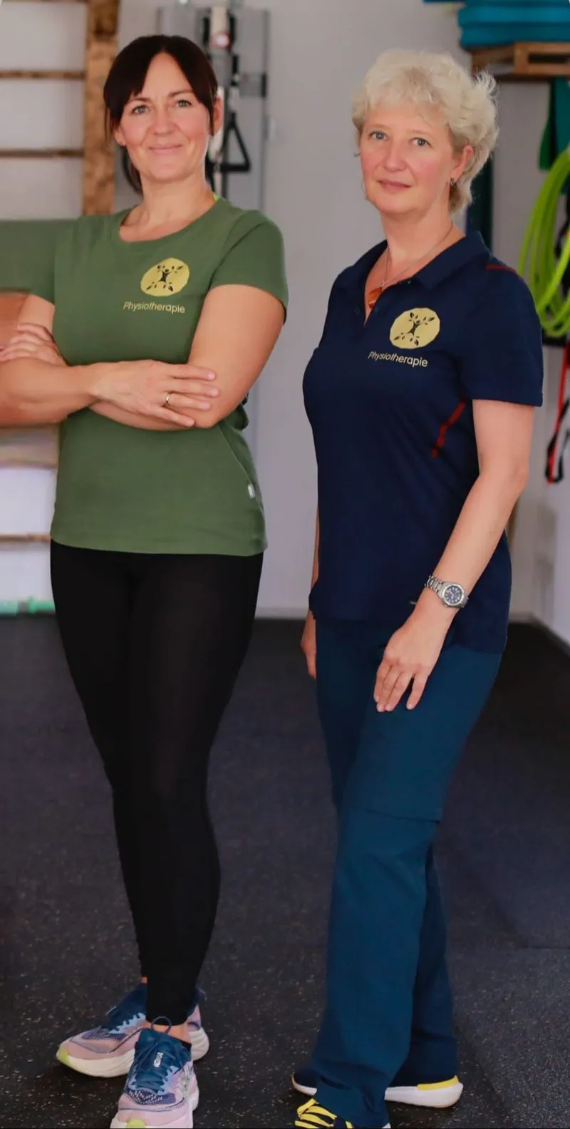 Maria Klaus und Lena Schmunk stehen nebeneinander im Trainingsraum der Praxis